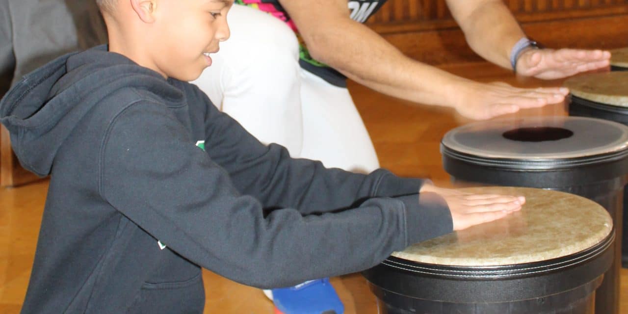 Kids bang away on Brazilian drums!